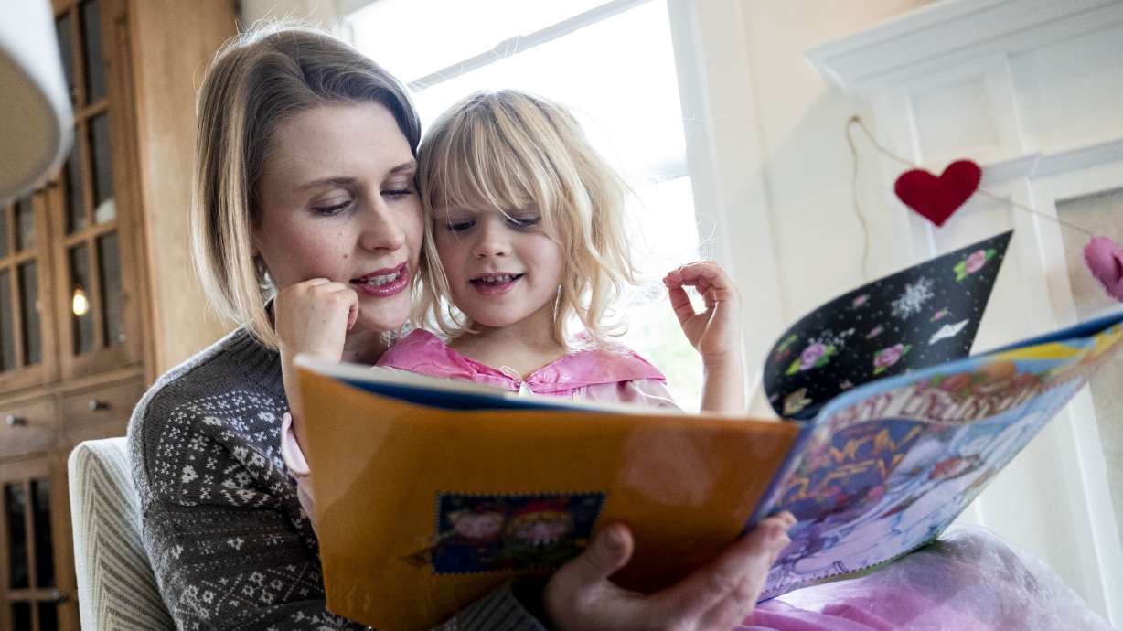 Rhiannon McDaniel reads to her daughter Brita, 4, at her family’s home in Holladay on Wednesday. The Policy Project is working with lawmakers in the Legislature to help young families who are trying to raise their children in Utah.