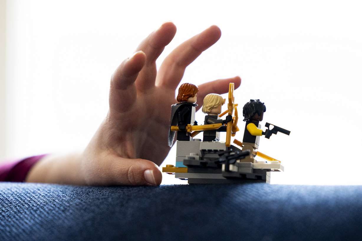 Atticus McDaniel, 7, grabs a Lego creation he assembled at his family’s home in Holladay on Wednesday. The McDaniel family is one of many feeling the pressure of rising child care costs in Utah.