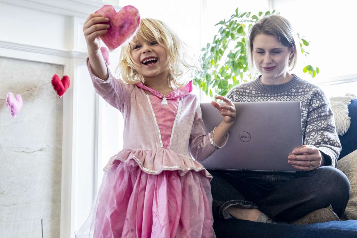 Brita McDaniel, 4, admires a heart she felted as her mother, Rhiannon, works on her laptop at her family’s home in Holladay on Wednesday. The Policy Project said in a press conference in January that 77% of Utah lives in child care deserts.