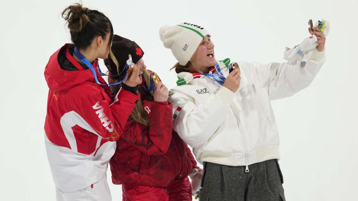 From left, silver medalist China's Eileen Gu, gold medalist Canada's Megan Oldham and bronze medalist Itay's Flora Tabanelli take a selfie after the women's freestyle skiing big air finals at the 2026 Winter Olympics, in Livigno, Italy, Monday, Feb. 16, 2026.