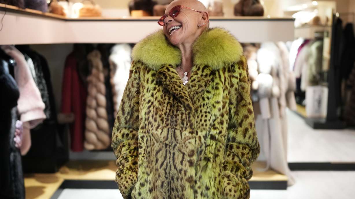 Paola De Leidi poses for a photo wearing a fur coat after an interview with The Associated Press in the Pajaro shop, in Cortina d'Ampezzo, Italy, Saturday, Feb. 14, 2026.