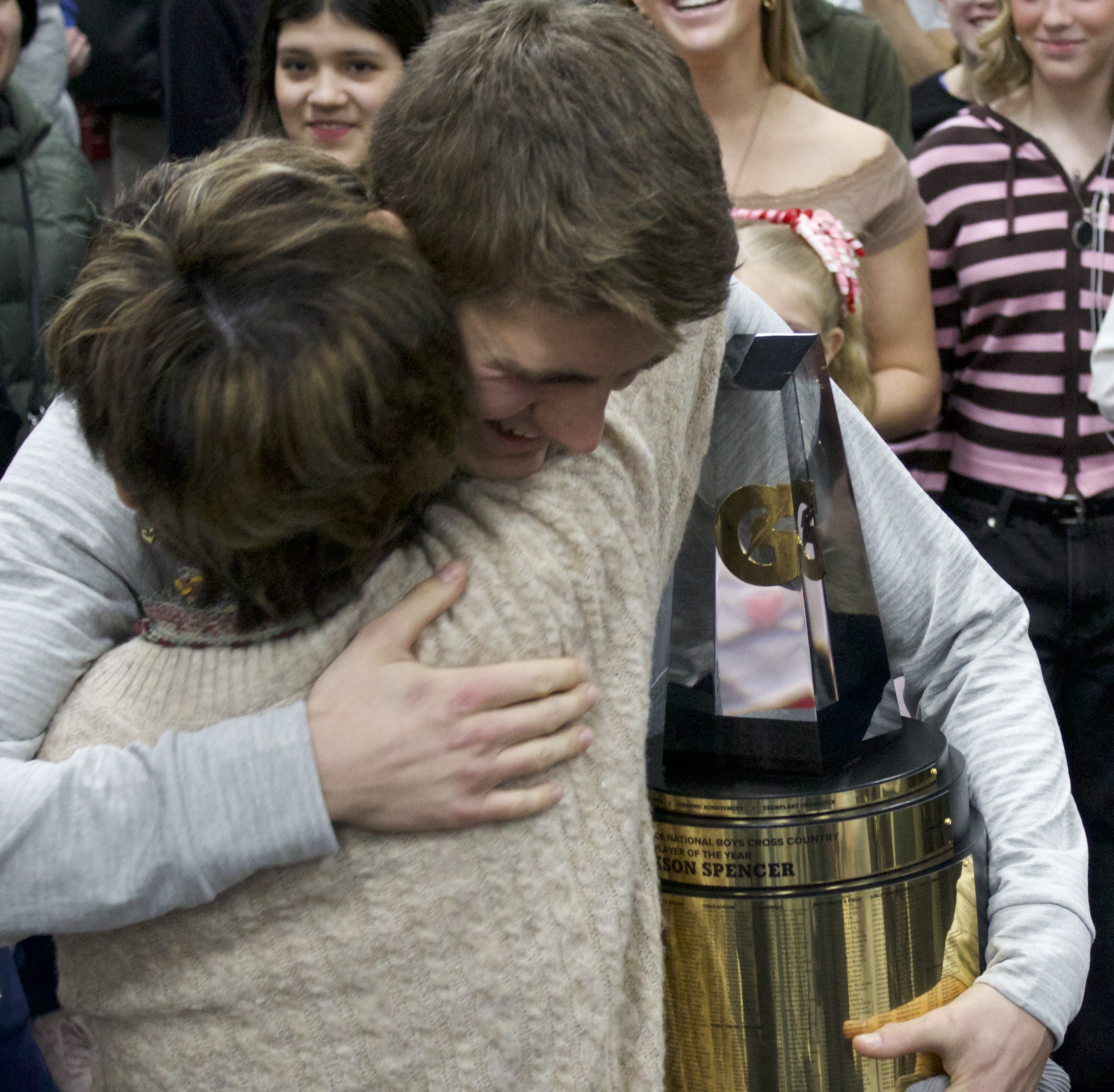 Herriman's Jackson Spencer hugs his family members after being named the 2025-26 national player of the year for boys' cross country by Gatorade, Wednesday, Feb. 18, 2026 in Herriman, Utah.