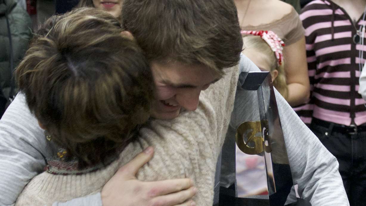 Herriman's Jackson Spencer hugs his family members after being named the 2025-26 national player of the year for boys' cross country by Gatorade, Wednesday, Feb. 18, 2026 in Herriman, Utah.