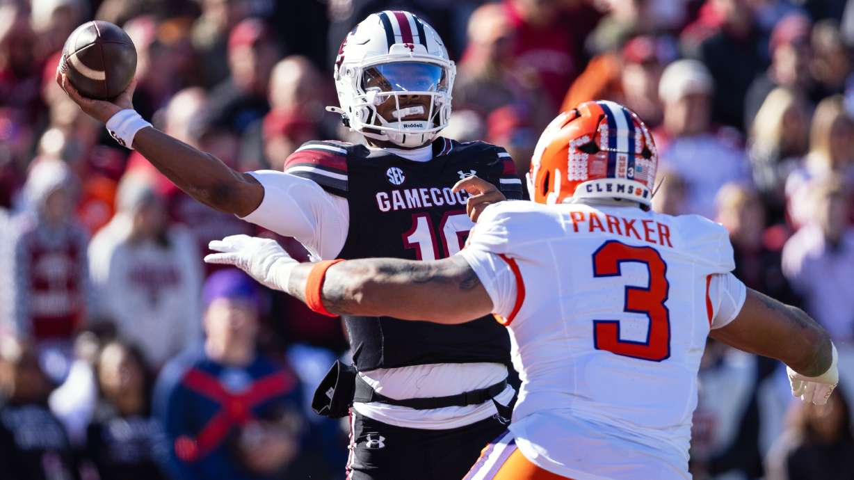 FILE - South Carolina quarterback Lanorris Sellers (16) throws under pressure from Clemson defensive end T.J. Parker (3) during the first half of an NCAA college football game, Nov. 29, 2025, in Columbia, S.C.