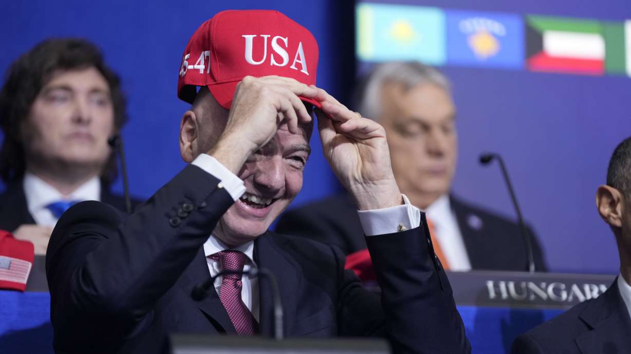 Giovanni Vincenzo Infantino, president of FIFA, tries out a USA hat during a Board of Peace meeting at the U.S. Institute of Peace, Thursday, Feb. 19, 2026, in Washington.