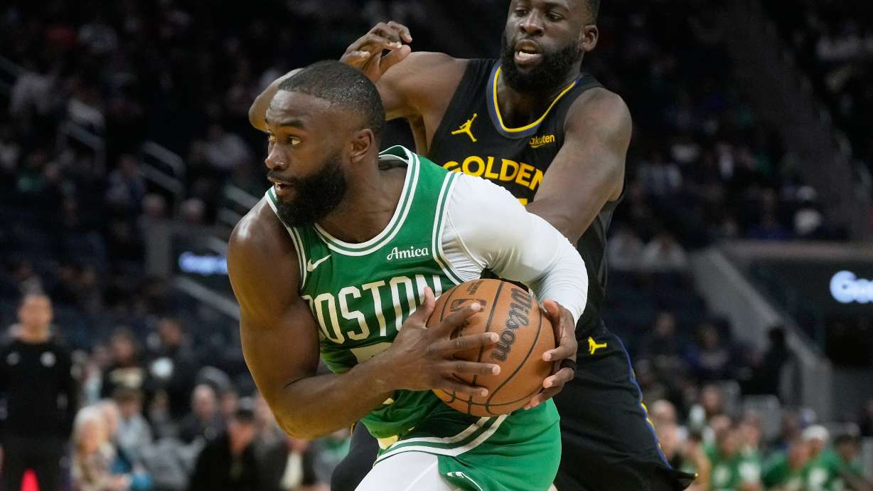 Boston Celtics guard Jaylen Brown, bottom, drives to the basket against Golden State Warriors forward Draymond Green during the second half of an NBA basketball game in San Francisco, Thursday, Feb. 19, 2026.
