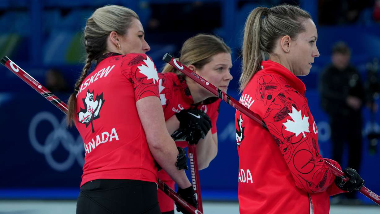 Canada's Emma Miskew, left, Rachel Homan, right, and Sarah Wilkes study the situation during a women's curling semifinal match against Sweden, at the 2026 Winter Olympics, in Cortina d'Ampezzo, Italy, Friday, Feb. 20, 2026.