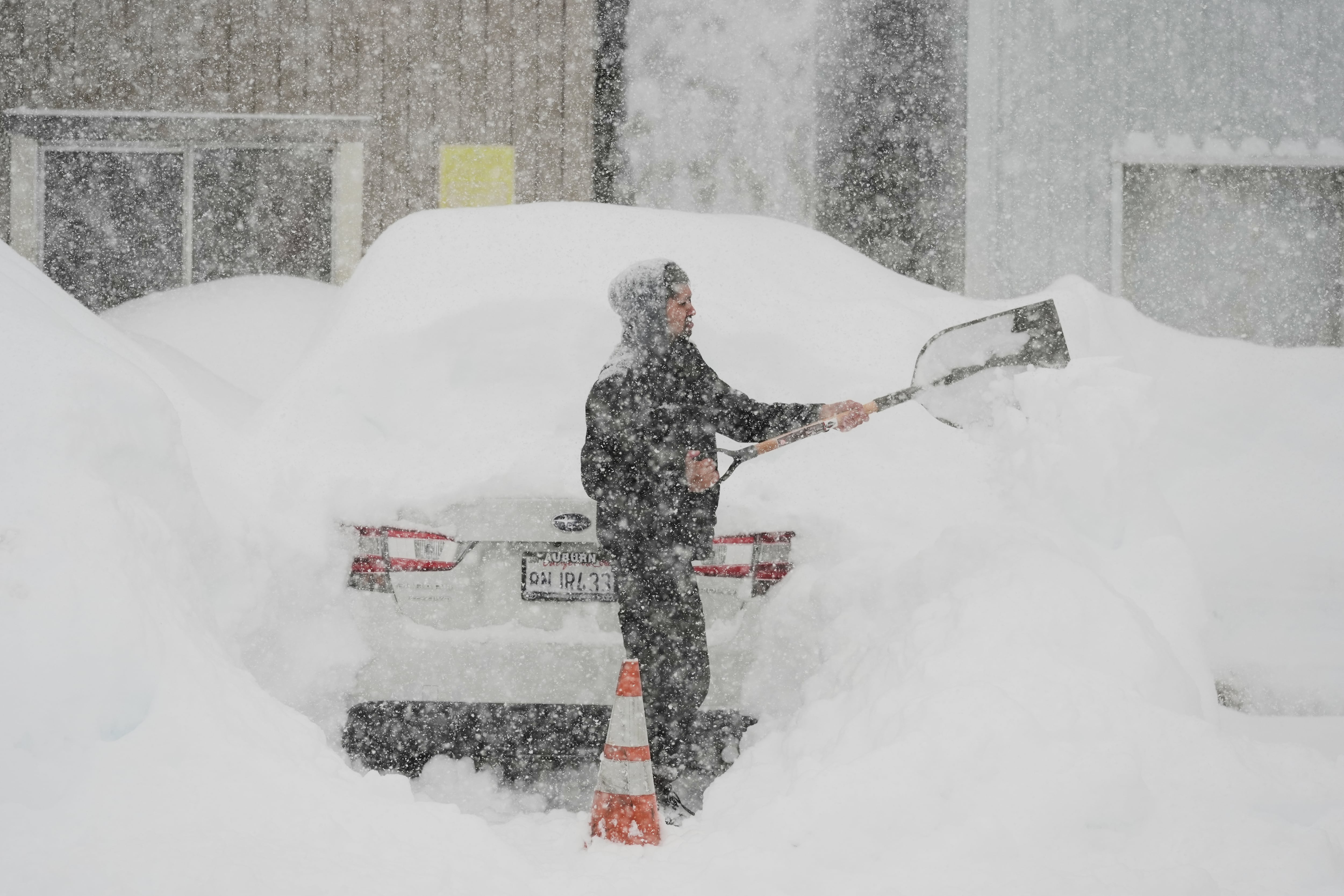 Adrián Narayan digs his car out of the snow Thursday, in Soda Springs, California.