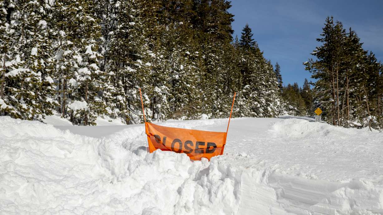 A closed sign is partially buried at the entrance to the Castle Peak trailhead in Soda Springs, Calif., Friday, Feb. 20, 2026.