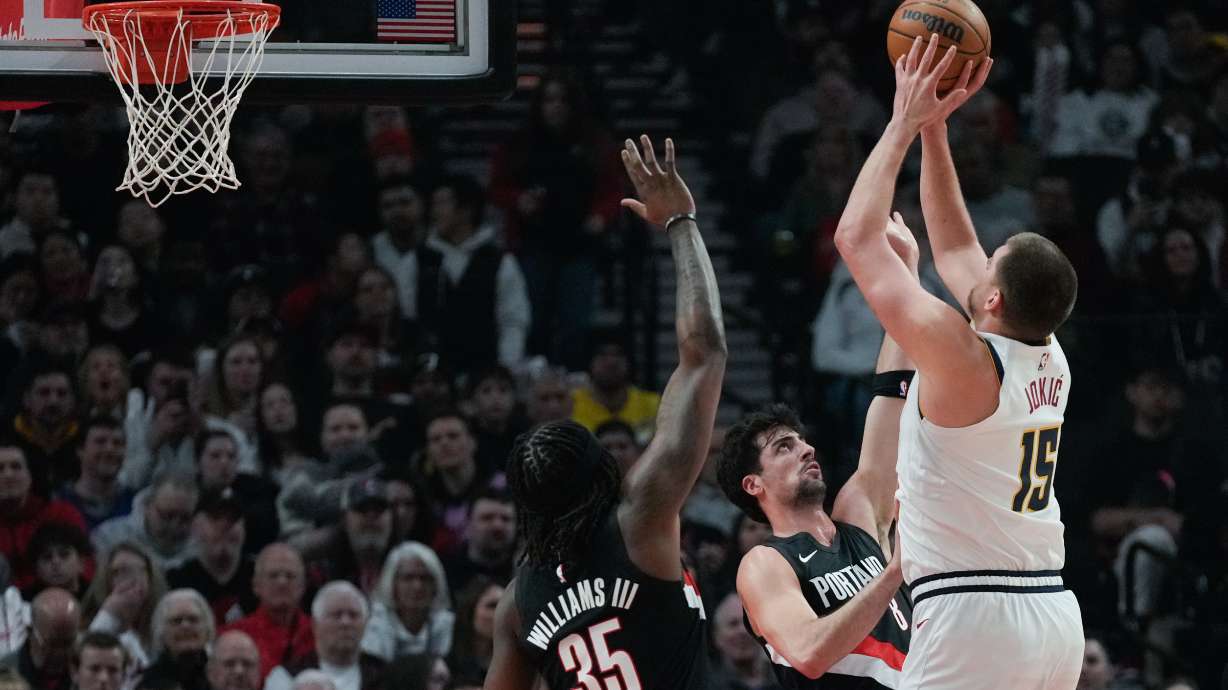 Portland Trail Blazers forward Deni Avdija (8) tries to block a shot by Denver Nuggets center Nikola Jokić (15) during the first half of an NBA basketball game Friday, Feb. 20, 2026, in Portland, Ore.