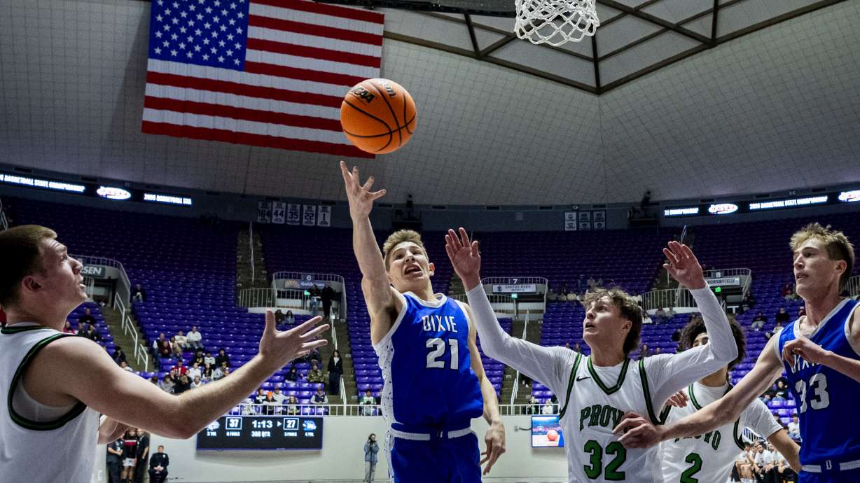 Dixie forward Jackson Winters (21) reaches for an offensive rebound along with Provo guard Lucas Castagnetto (32) during the semifinals of the 4A boys basketball state tournament held at the Dee Events Center in Ogden on Friday, Feb. 20, 2026.