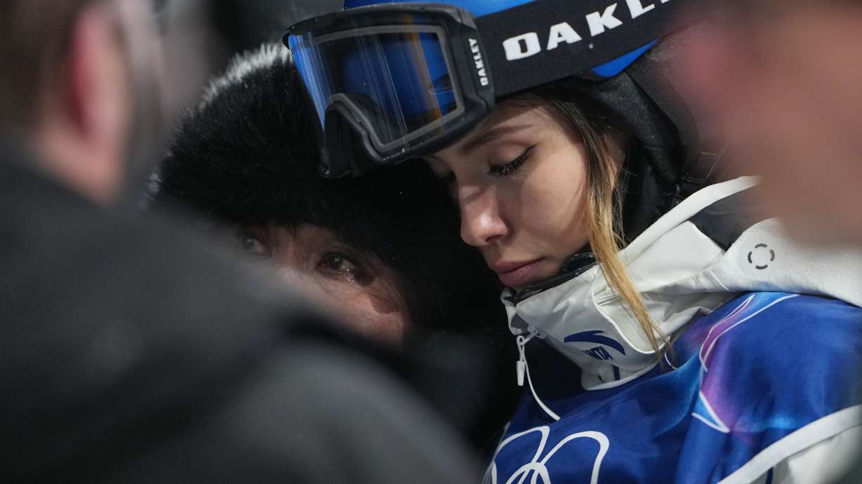China's Eileen Gu, right, reacts alongside her mother, Yan Gu, after Canada's Cassie Sharpe crashed during the women's freestyle skiing halfpipe qualifications at the 2026 Winter Olympics, in Livigno, Italy, Thursday, Feb. 19, 2026.