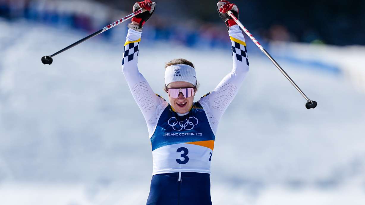 Ebba Andersson, of Sweden, crosses the finish line to win the gold medal in the cross country skiing women's 50km mass start classic at the 2026 Winter Olympics, in Tesero, Italy, Sunday, Feb. 22, 2026.