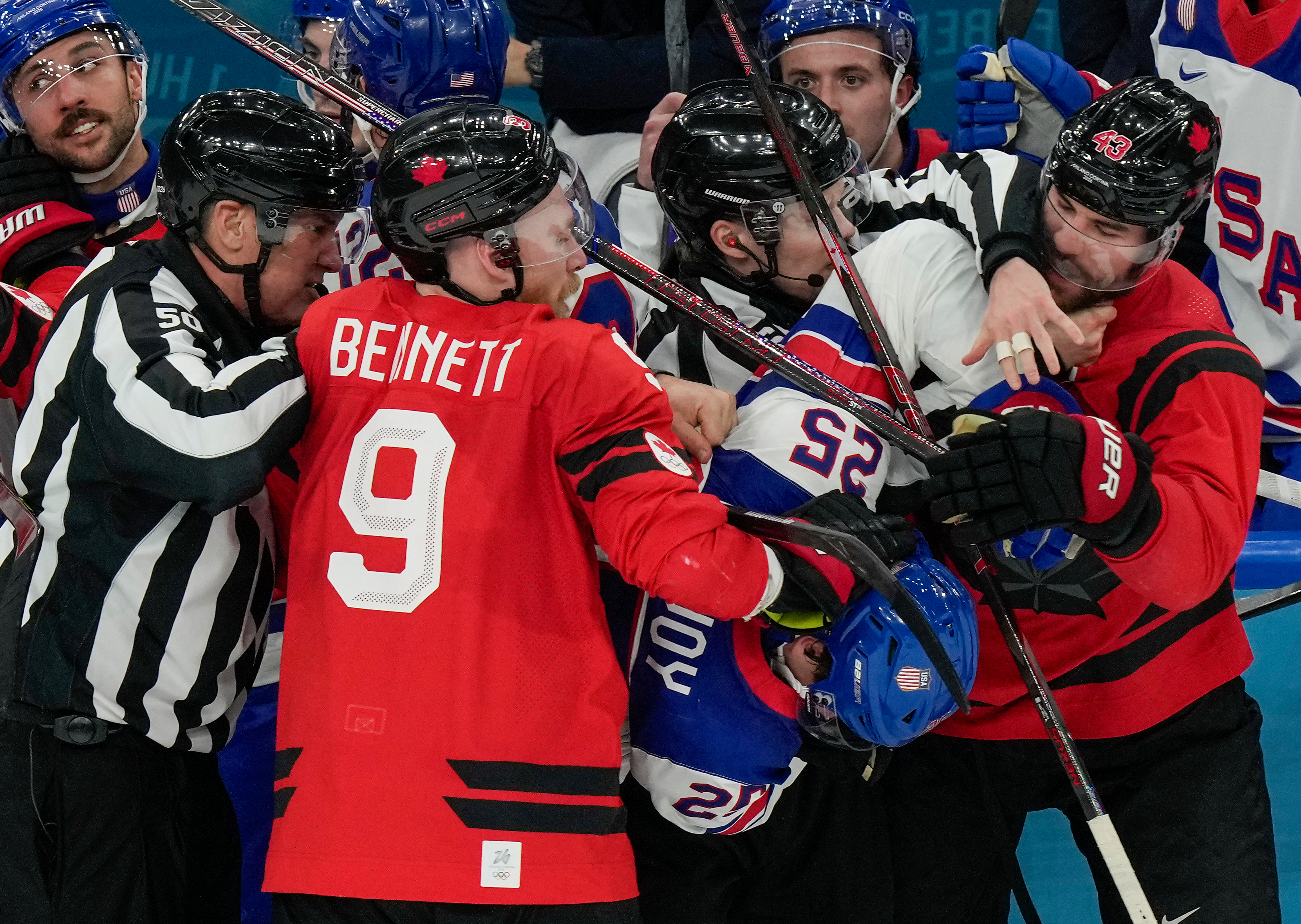 Referees try to break up a fight between Canada's Sam Bennett (9), United States' Charlie McAvoy (25) and Canada's Tom Wilson (43) during the second period of the men's ice hockey gold medal game at the 2026 Winter Olympics, in Milan, Italy, Sunday.