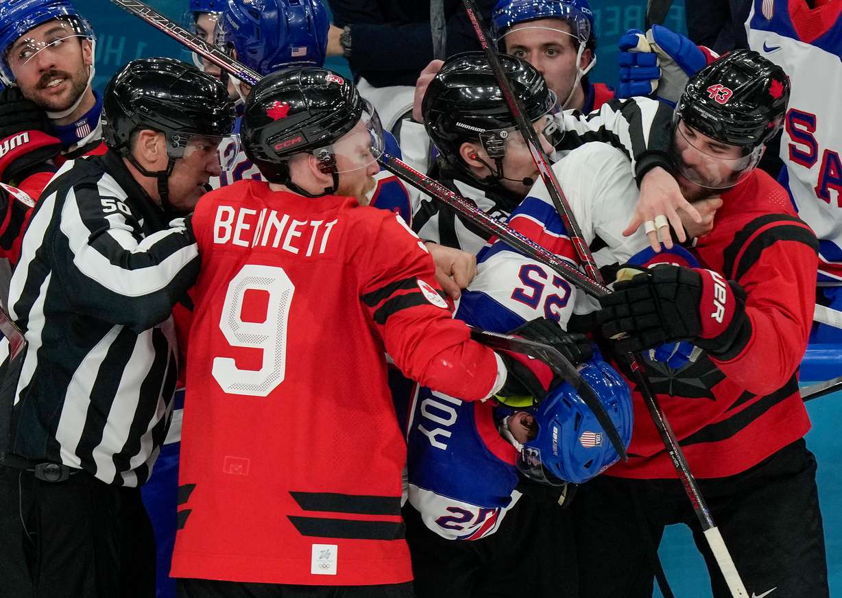 Referees try to break up a fight between Canada's Sam Bennett (9), United States' Charlie McAvoy (25) and Canada's Tom Wilson (43) during the second period of the men's ice hockey gold medal game at the 2026 Winter Olympics, in Milan, Italy, Sunday.