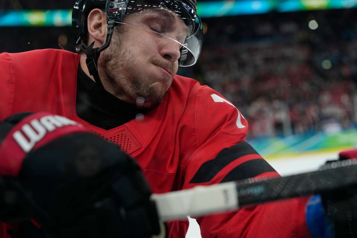 Canada's Bo Horvat (14) crashes into the boards during a men's ice hockey gold medal game between Canada and the United States at the 2026 Winter Olympics, in Milan, Italy, Sunday.