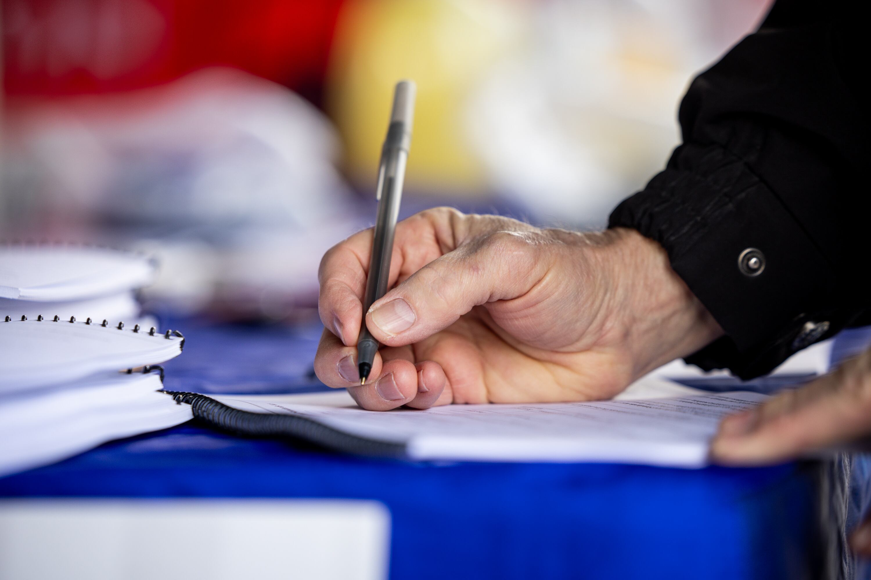 A person signs a petition to repeal Proposition 4 at a Turning Point Action signature gathering event at Union Park in Midvale on Feb. 12.
