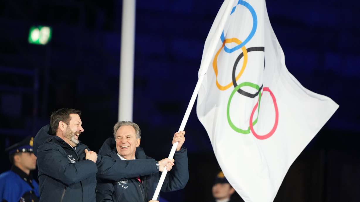 President of the Provence-Alpes-Cote d'Azur Region Renaud Muselier, right, and President of the Auvergne-Rhone-Alpes Region Fabrice Pannekoucke wave the Olympic flag during the closing ceremony of the 2026 Winter Olympics, in Verona, Italy, Sunday, Feb. 22, 2026.