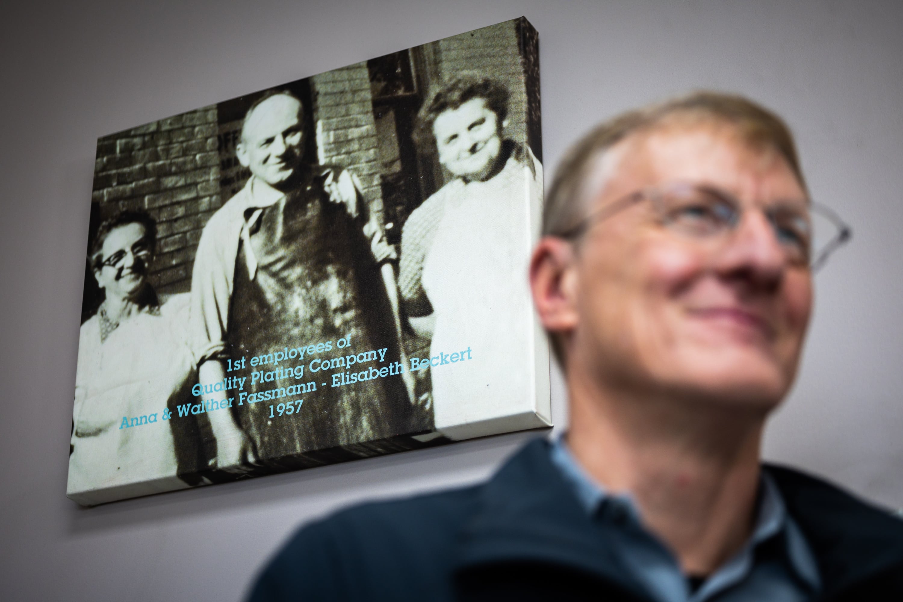 Glenn Fassmann, owner and operator at Quality Plating Co. Inc., next to a photo of his grandmothers, Anna Fassmann and Elisabeth Beckert, and his grandfather, Walther Fassmann, at Quality Plating Co. Inc.'s main plant in Salt Lake City on Feb. 4. The family business is closing its doors in March.