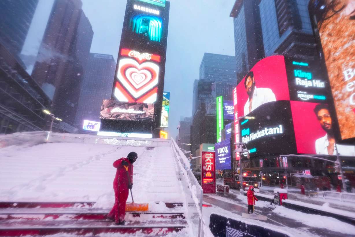 A worker with the Times Square Alliance sanitation crew clears snow from the Red Stairs in Times Square, Monday, in New York.