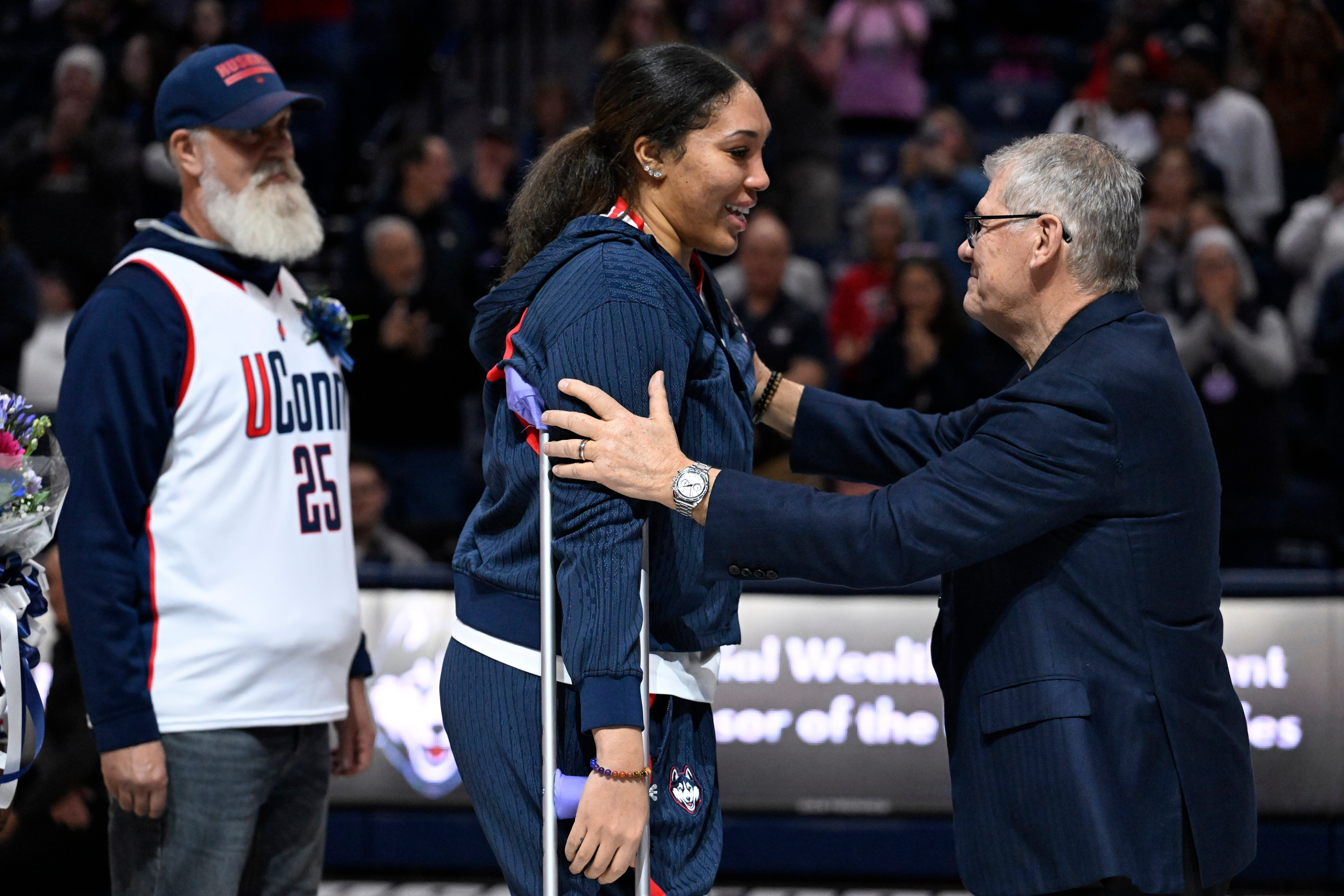UConn head coach Geno Auriemma, right, reaches for UConn forward Ice Brady, center, as she is honored in a Senior Day ceremony after an NCAA college basketball game against Providence, Sunday, Feb. 22, 2026, in Storrs, Conn. 