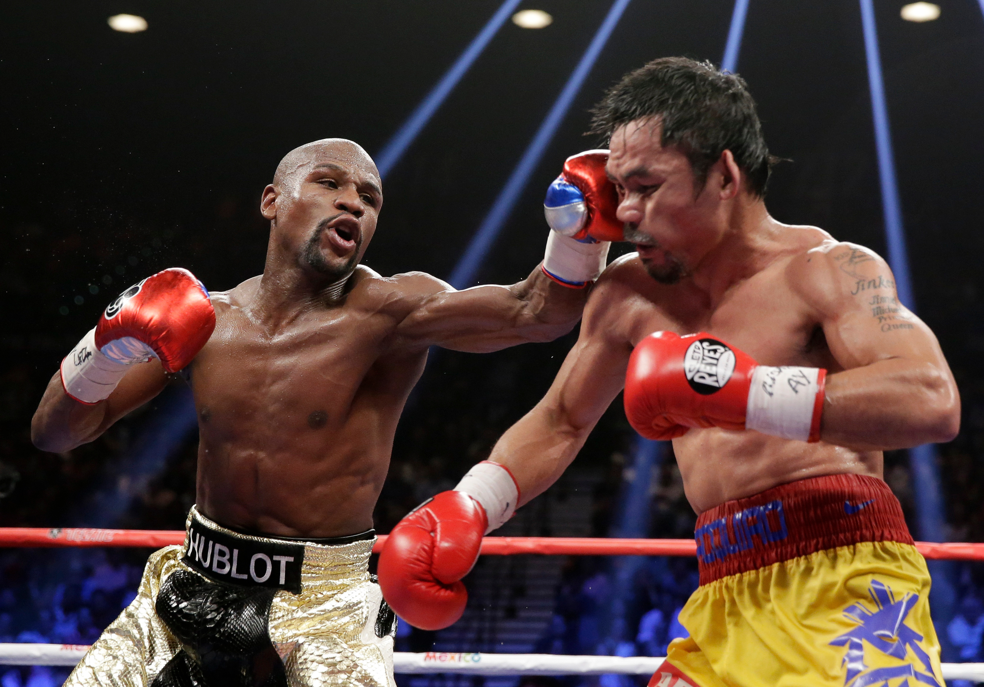 FILE - Floyd Mayweather Jr., left, hits Manny Pacquiao, from the Philippines, during their welterweight title fight on May 2, 2015, in Las Vegas.