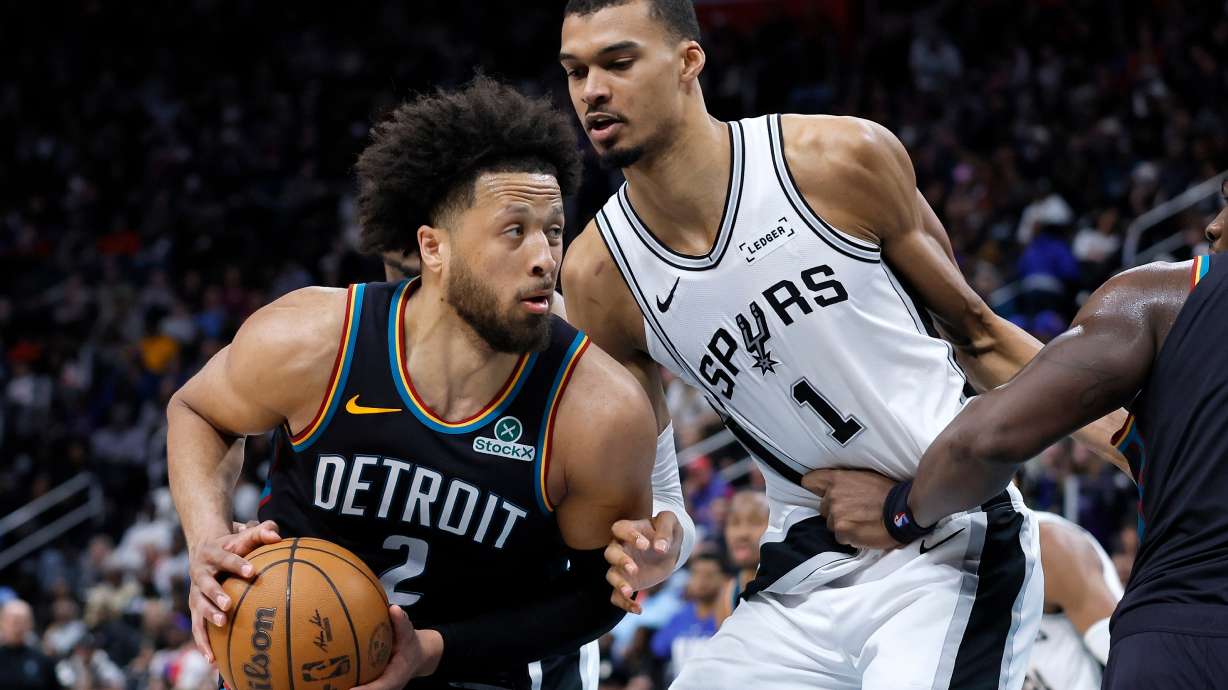 Detroit Pistons guard Cade Cunningham (2) drives against San Antonio Spurs forward Victor Wembanyama (1) during the second half of an NBA basketball game Monday, Feb. 23, 2026, in Detroit.