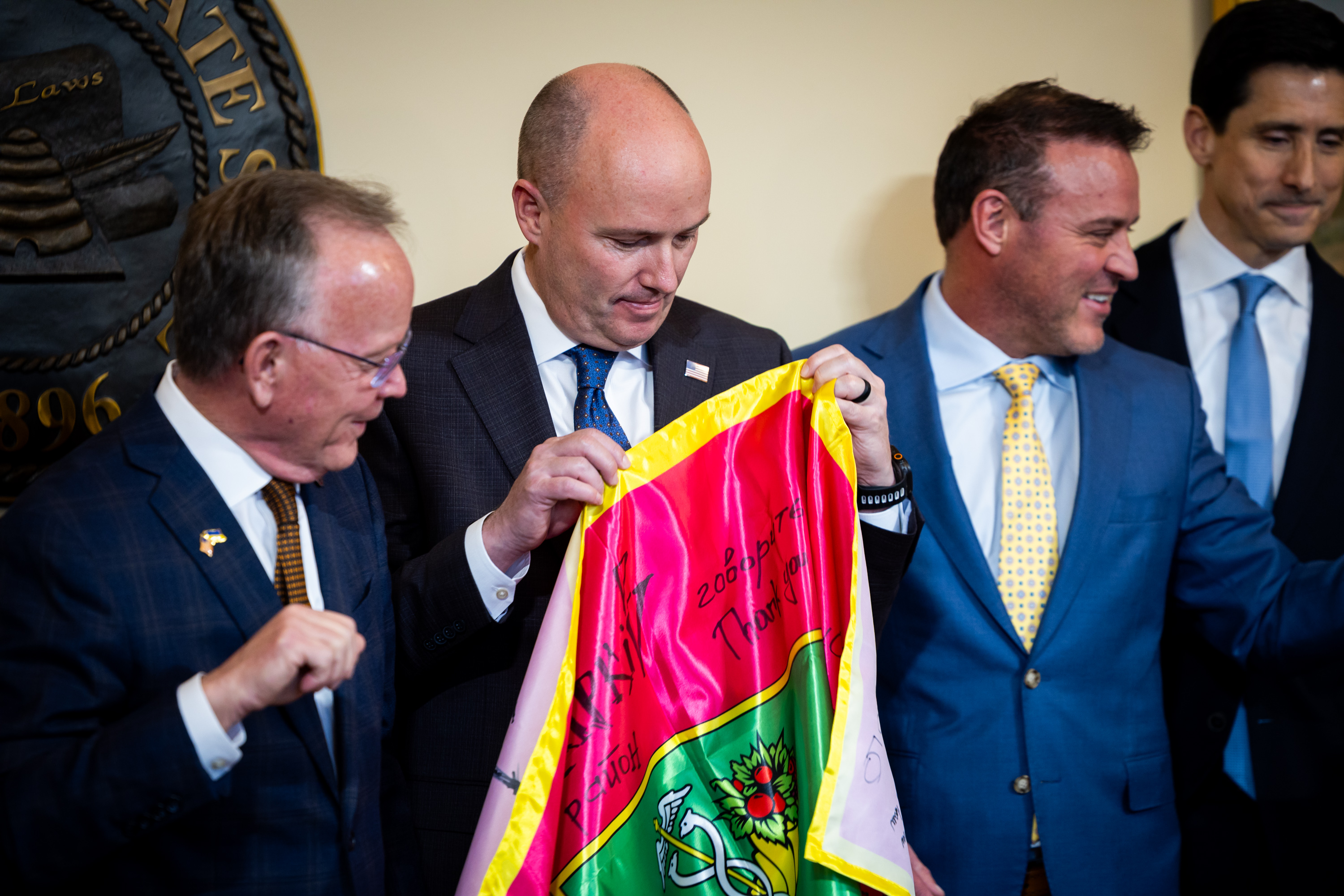 Gov. Spencer Cox, center, holds a flag from Ukraine’s Kharkiv Regional Council on the fourth anniversary of Russia’s invasion of Ukraine at the Capitol in Salt Lake City on Tuesday.
