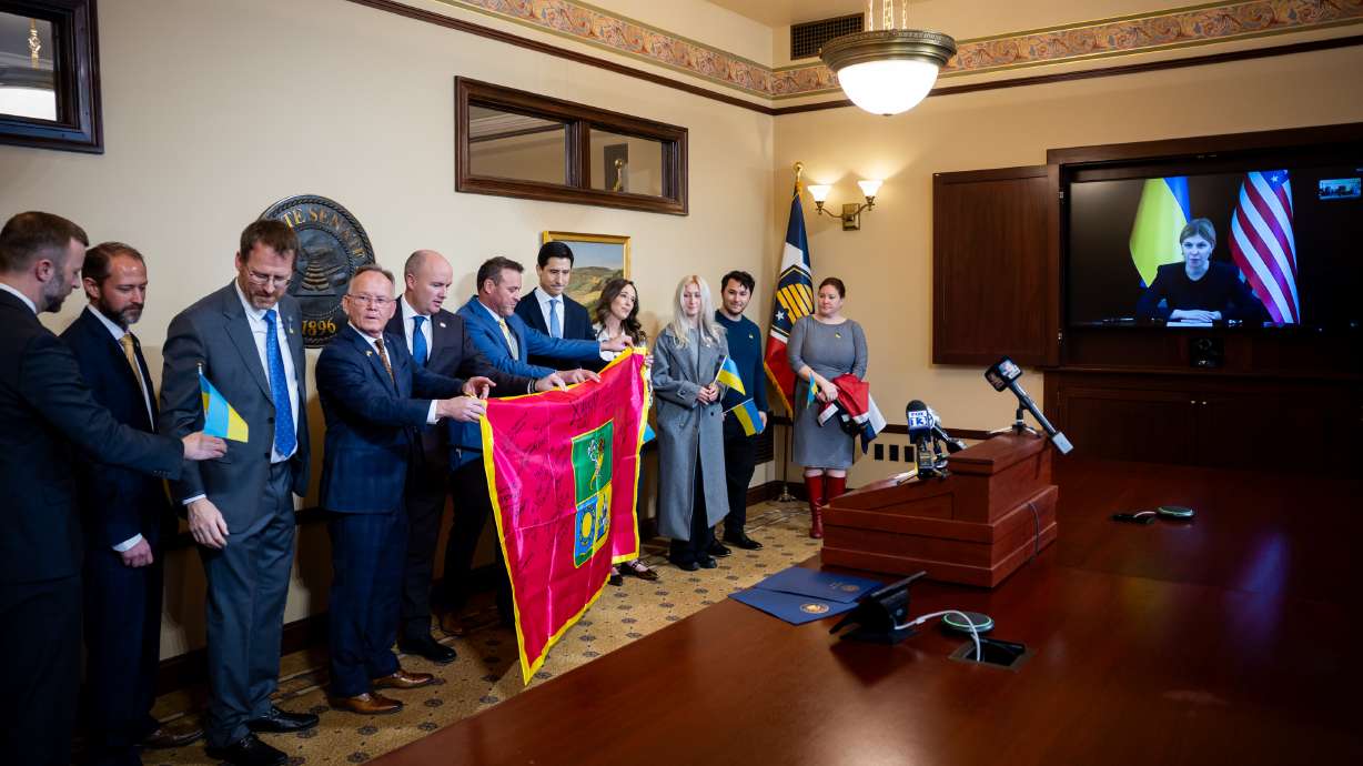 Utah state leaders accept a flag from Ukraine’s Kharkiv Regional Council while on a Zoom call with Ukrainian Ambassador Olga Stefanishyna on the fourth anniversary of Russia’s invasion of Ukraine at the Capitol in Salt Lake City on Tuesday.