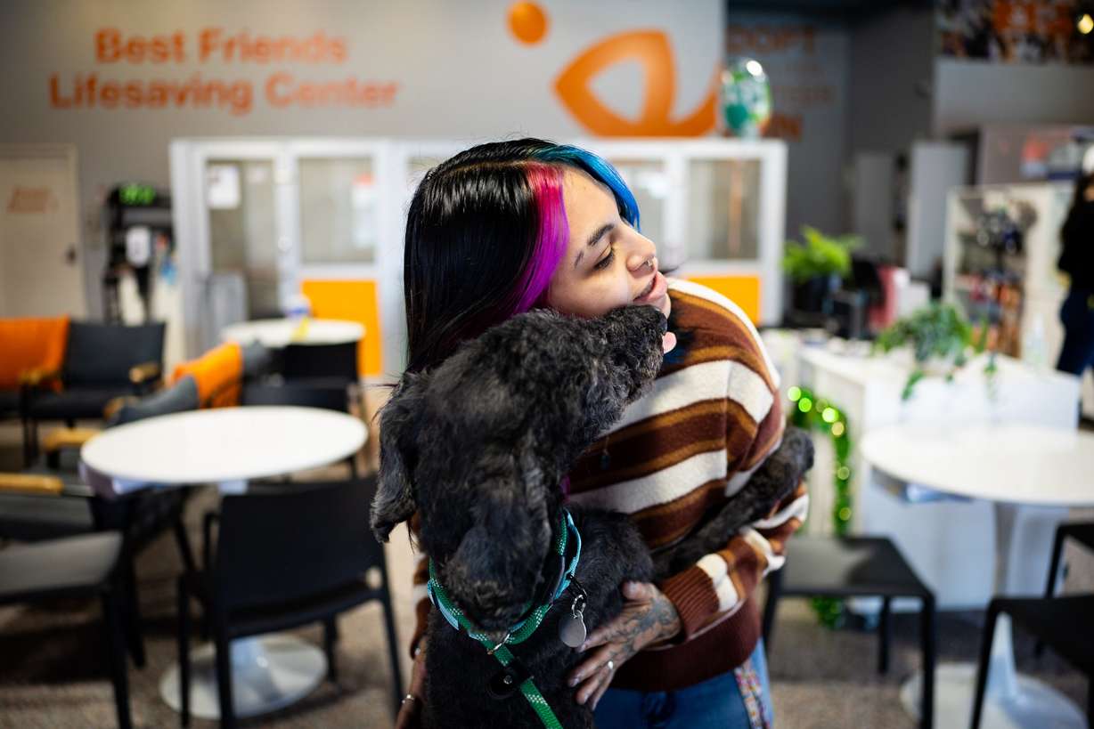 Alex Mejia, senior adoption specialist at the Best Friends Animal Society, hugs Benny as he arrives back from a walk at the Best Friends Animal Society in Salt Lake City on Wednesday. Utah lawmakers are working on legislation to aid shelter animals.