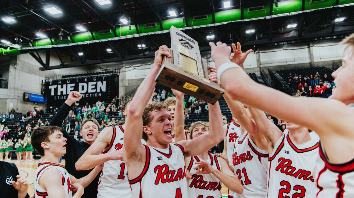 South Sevier's Cannon Barney lifts the trophy to celebrate a win over South Summit in the 2A boys basketball state championship game, Wednesday, Feb. 25, 2026 at the UCCU Center in Orem.