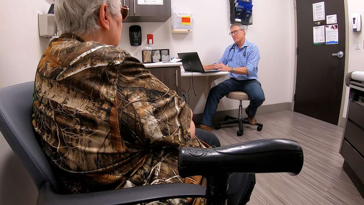 Eric Johnson with a patient at a medical clinic in Ogden, Wednesday. Johnson is also a long-distance runner in his spare time.