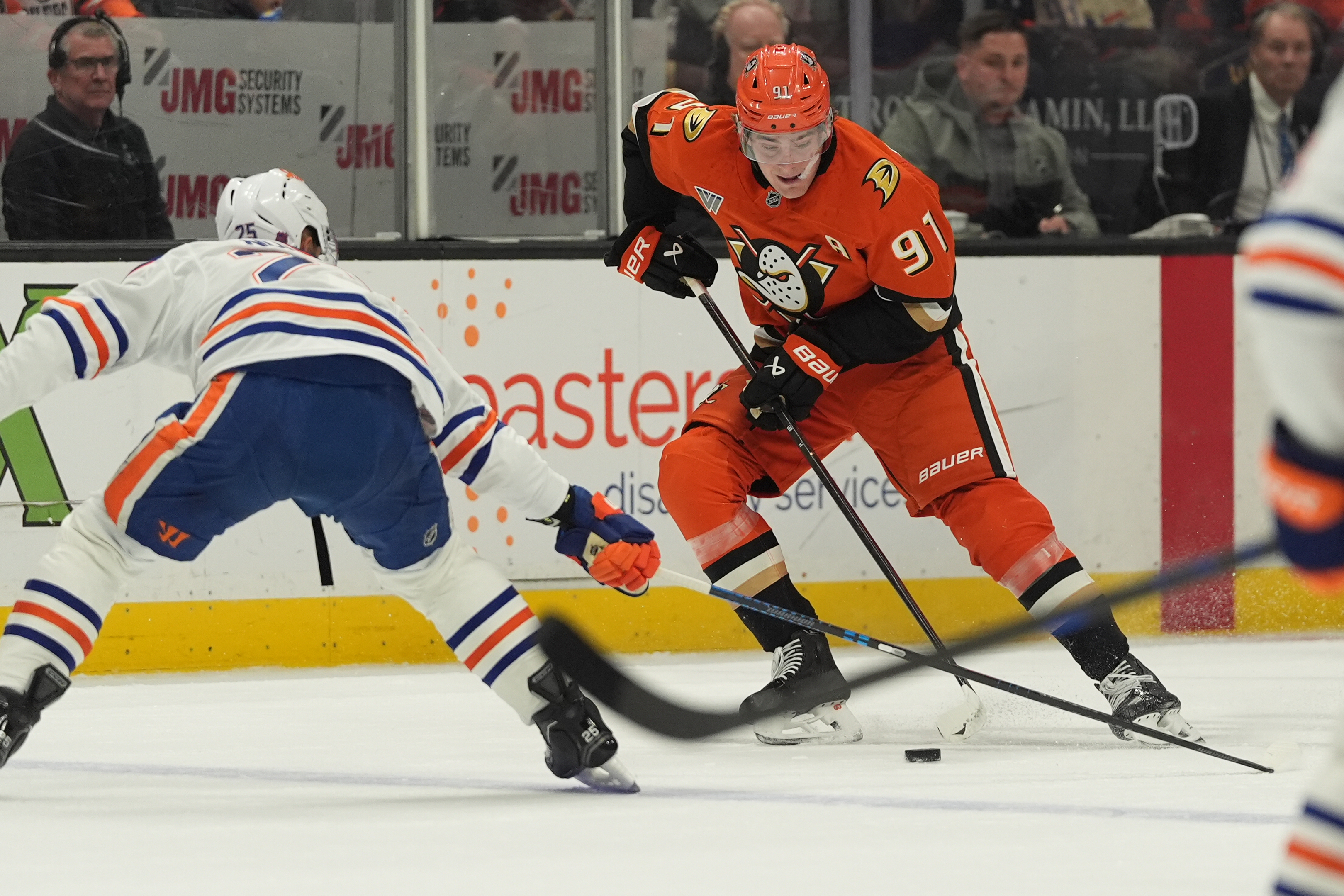 Anaheim Ducks center Leo Carlsson (91) looks to pass as Edmonton Oilers defenseman Darnell Nurse defends during the first period of an NHL hockey game Wednesday, Feb. 25, 2026, in Anaheim, Calif. 