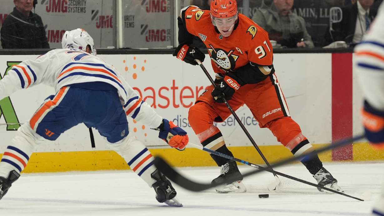 Anaheim Ducks center Leo Carlsson (91) looks to pass as Edmonton Oilers defenseman Darnell Nurse defends during the first period of an NHL hockey game Wednesday, Feb. 25, 2026, in Anaheim, Calif.