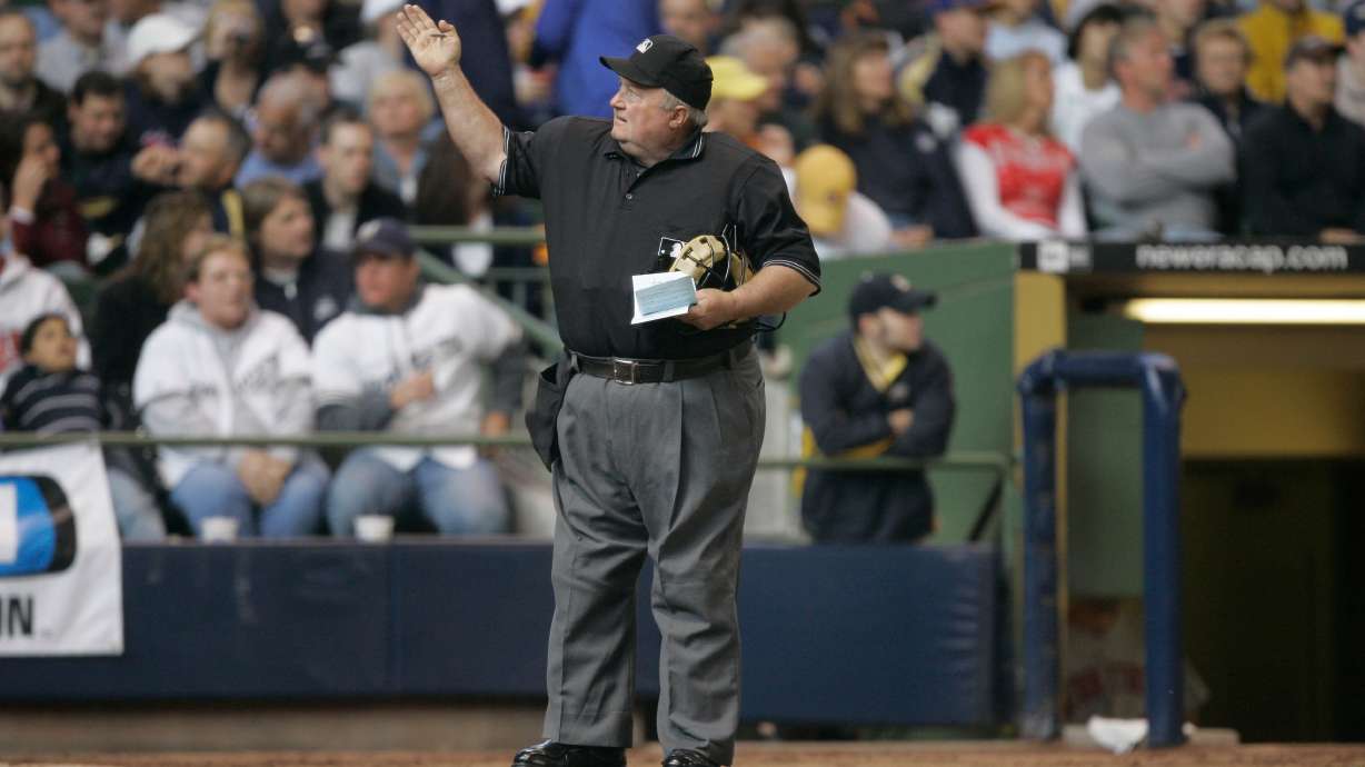 FILE - Home plate umpire Bruce Froemming signals to the official scorer during the fifth inning of a baseball game May 20, 2007, in Milwaukee.