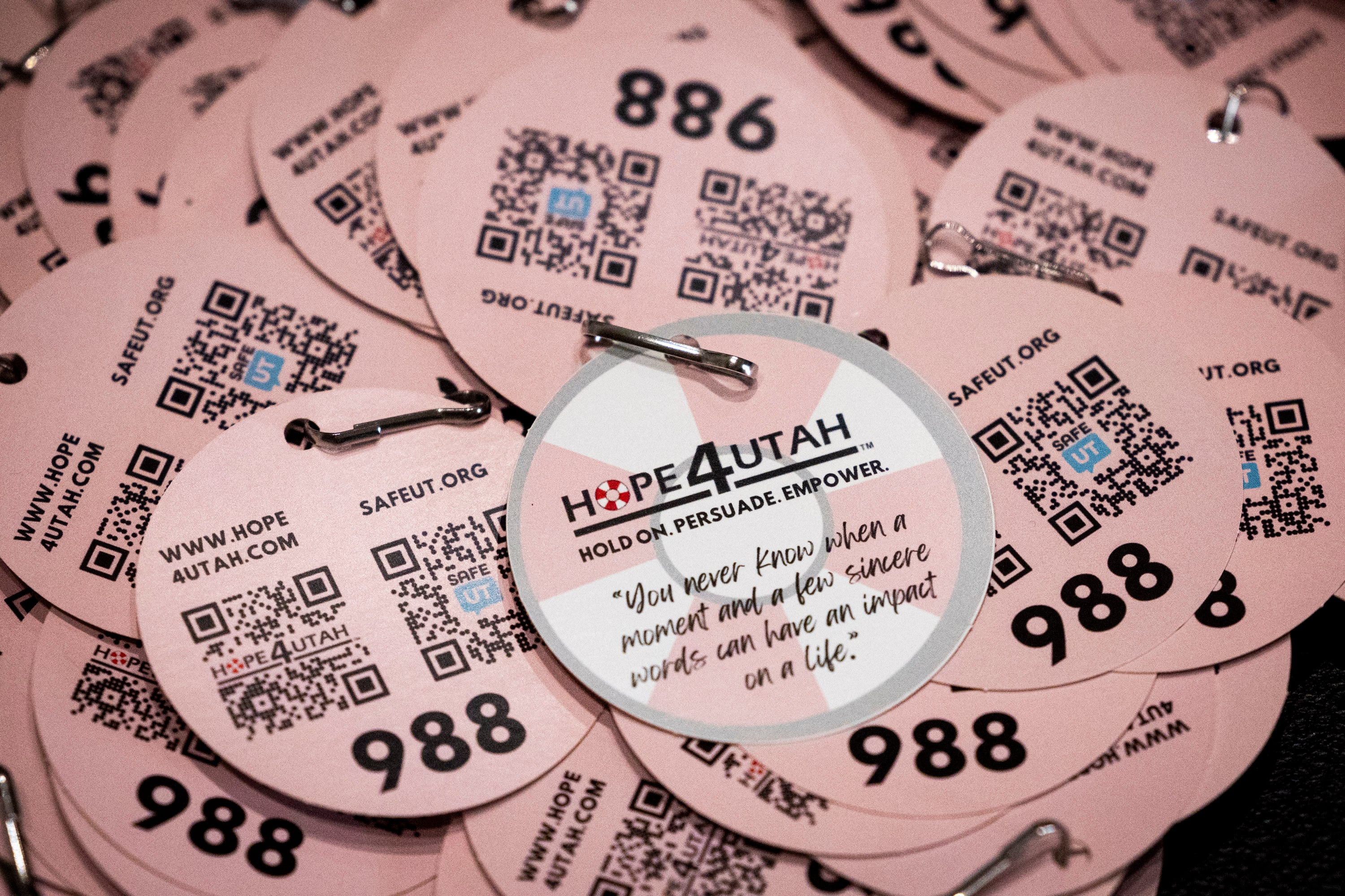 Informational tags about the Suicide and Crisis Lifeline that can be attached to backpacks are made available for students to take before a conference teaching suicide prevention training held by Hope4Utah at Mountain View High School in Orem on Feb. 19. Research says most mental illnesses begin between ages 10 to 14.