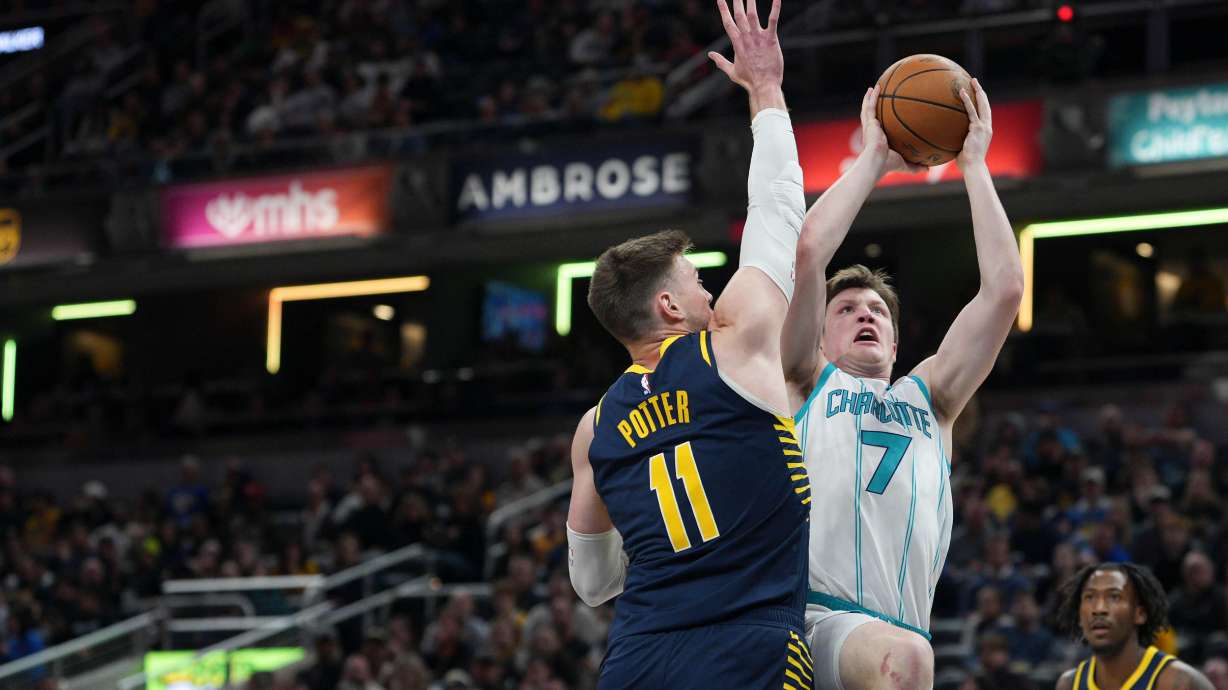 Charlotte Hornets guard Kon Knueppel (7) looks to shoot around Indiana Pacers center Micah Potter (11) during the first half of an NBA basketball game in Indianapolis, Thursday, Feb. 26, 2026.