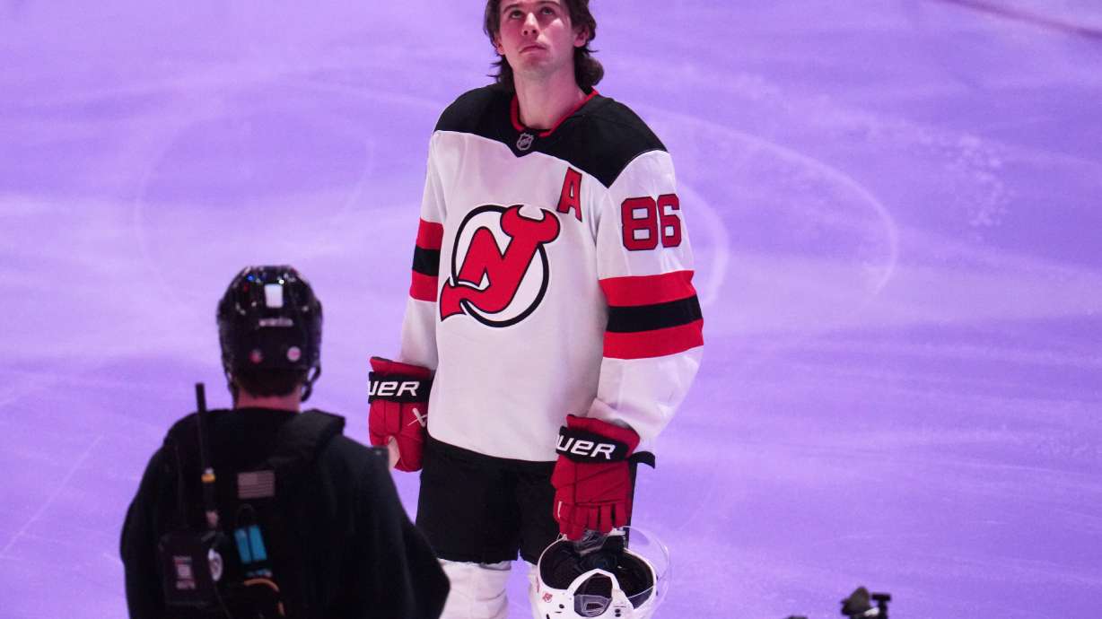 New Jersey Devils' Jack Hughes is honored along with other Olympic hockey players present before an NHL hockey game against the Pittsburgh Penguins in Pittsburgh, Thursday, Feb. 26, 2026.