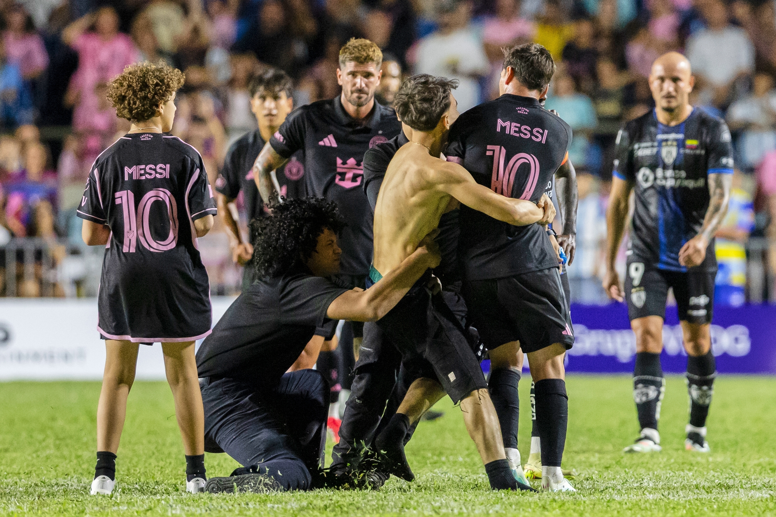 A fan who got onto the field grabs Inter Miami's Lionel Messi at the end of an international friendly soccer match against Ecuador's Independiente del Valle in Bayamon, Puerto Rico, Thursday, Feb. 26, 2026. 
