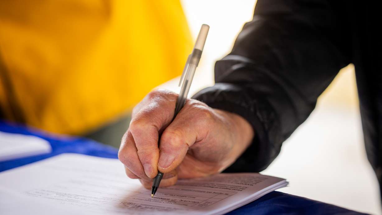 A person signs a petition to repeal Proposition 4 at Union Park in Midvale on Feb. 12. The future of a ballot initiative to repeal Proposition 4 sits on a knife's edge after narrowly clearing the signature threshold in the last needed Senate district Friday.