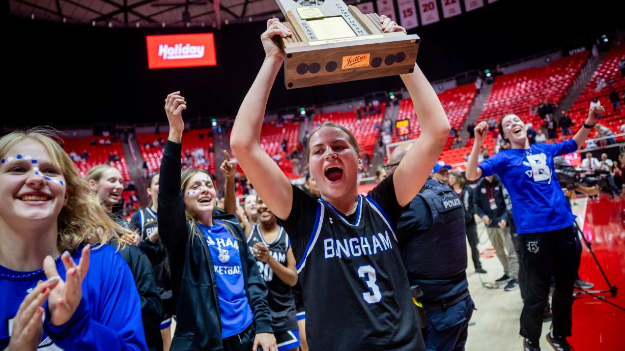 Bingham Miners Evalyn Roberts (3) celebrates with the trophy after winning against the Lone Peak Knights during the 6A girls basketball state championship game at the Jon M. Huntsman Center in Salt Lake City on Friday, Feb. 27, 2026.