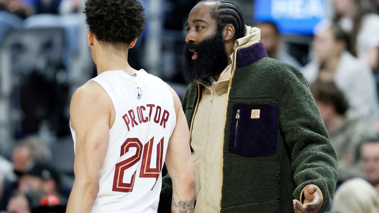 Cleveland Cavaliers guard James Harden, right, who is out injured with a right thumb fracture, talks with Cavaliers guard Tyrese Proctor (24) during the first half of an NBA basketball game Detroit Pistons, Friday, Feb. 27, 2026, in Detroit.