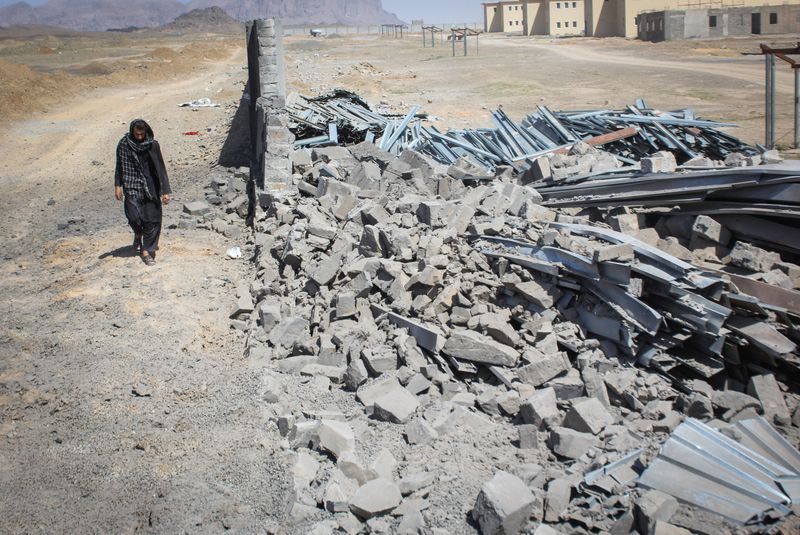 An Afghan man walks past a damaged wall following airstrikes, amid the conflict between Afghanistan and Pakistan, in Kandahar, Afghanistan, Saturday. 
