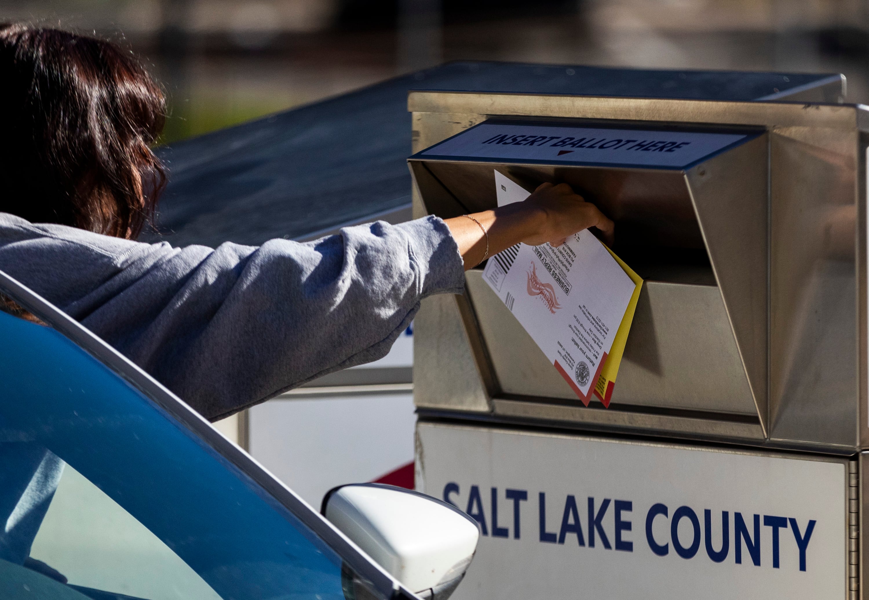 A voter drops off a ballot outside of the Salt Lake County Government Center in Salt Lake City on Nov. 4, 2024.