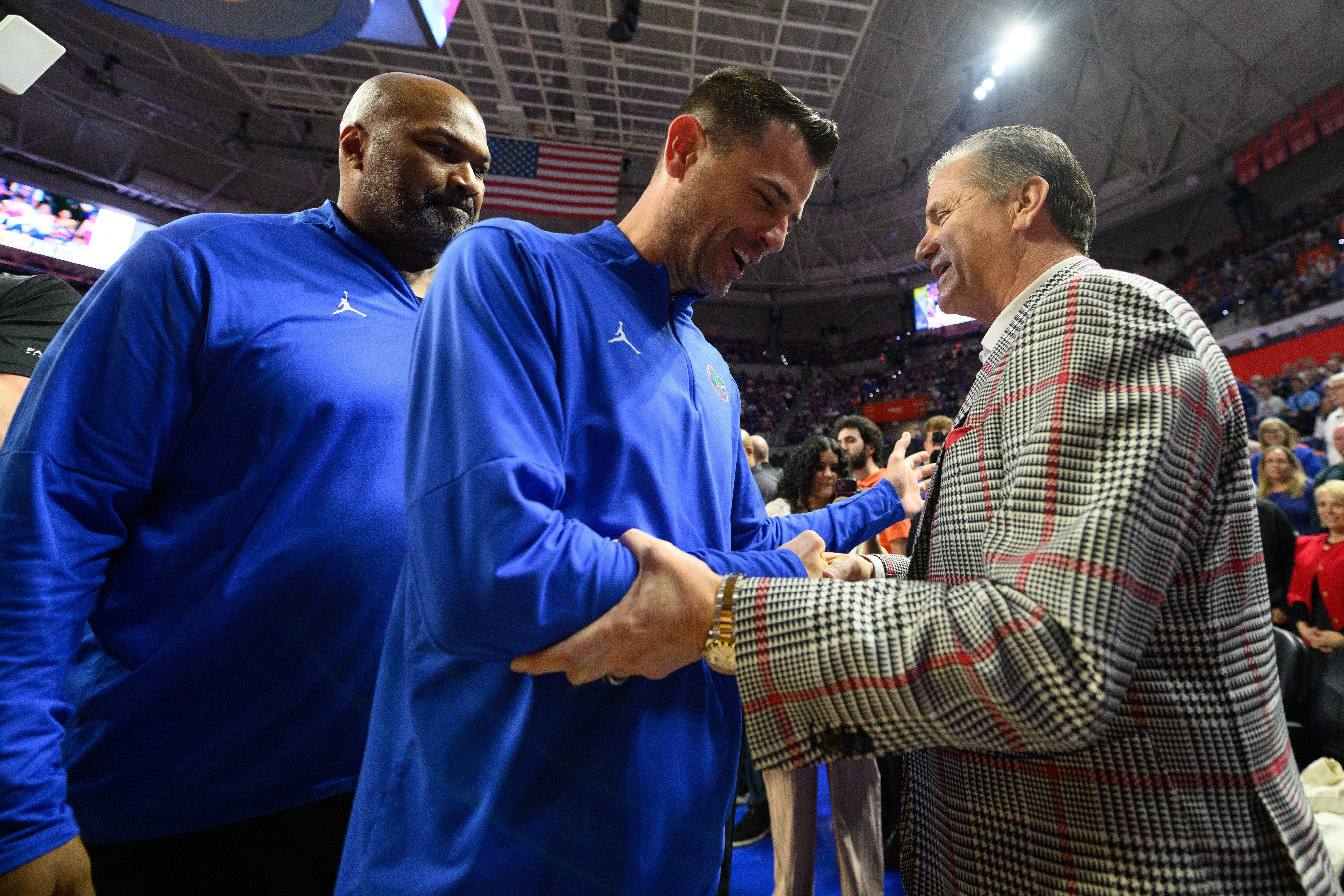 Florida head coach Todd Golden, center, shakes hands with Arkansas head coach John Calipari, right, before an NCAA college basketball game, Saturday, Feb. 28, 2026, in Gainesville, Fla. 