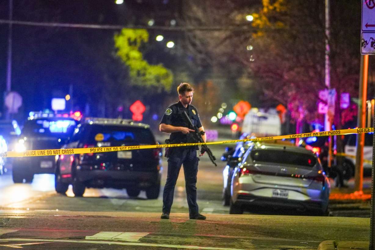 An Austin police officer guards the scene on West 6th Street at West Avenue after a shooting, Sunday, in Austin, Texas.
