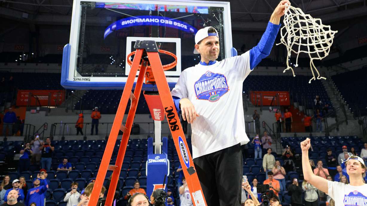 Florida head coach Todd Golden holds the net after clinching the SEC regular season championship after an NCAA college basketball game against Arkansas, Saturday, Feb. 28, 2026, in Gainesville, Fla.