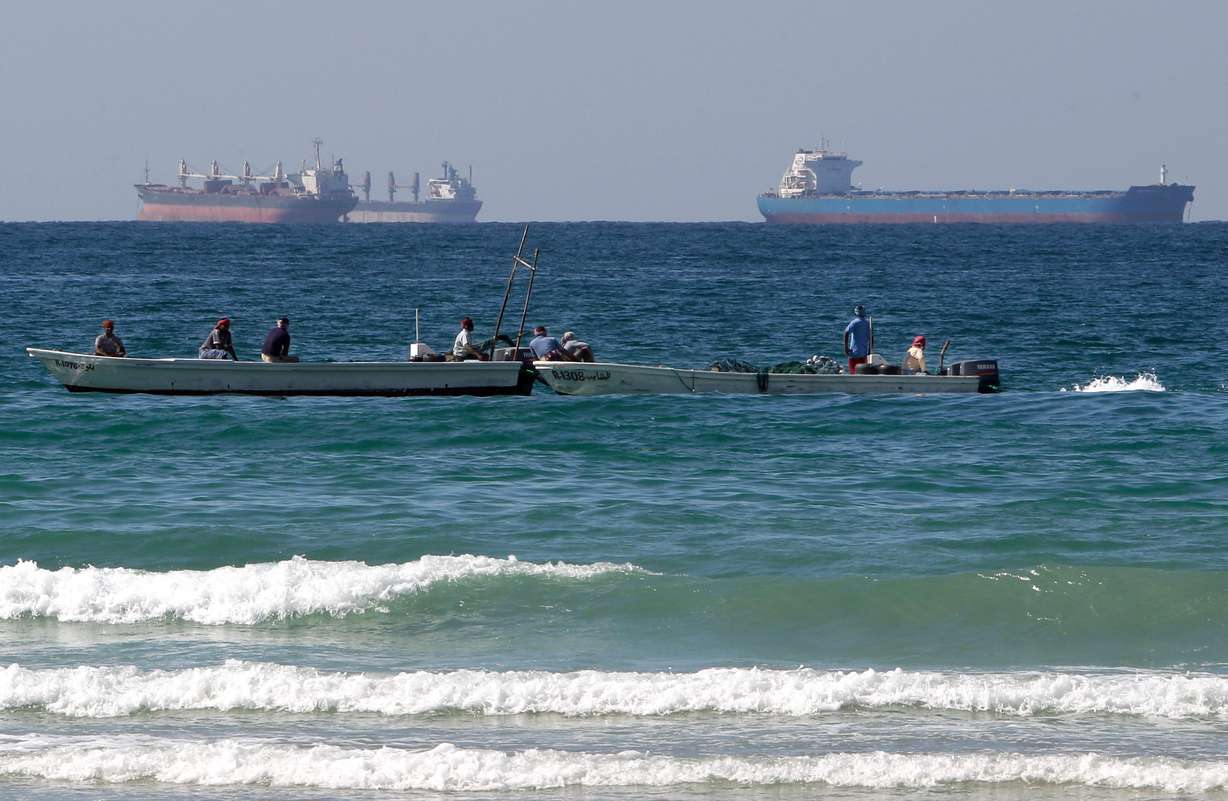 Fishermen work in front of oil tankers south of the Strait of Hormuz on Jan. 19, 2012, offshore the town of Ras Al Khaimah in the United Arab Emirates.