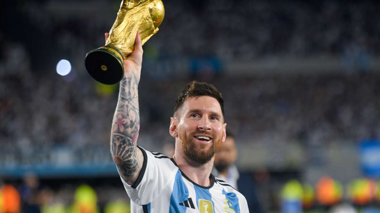 FILE - Argentina's Lionel Messi hoists the winning team replica of the FIFA World Cup trophy during a celebration ceremony for local fans after an international friendly soccer match against Panama at the Monumental stadium in Buenos Aires, Argentina, March 23, 2023.