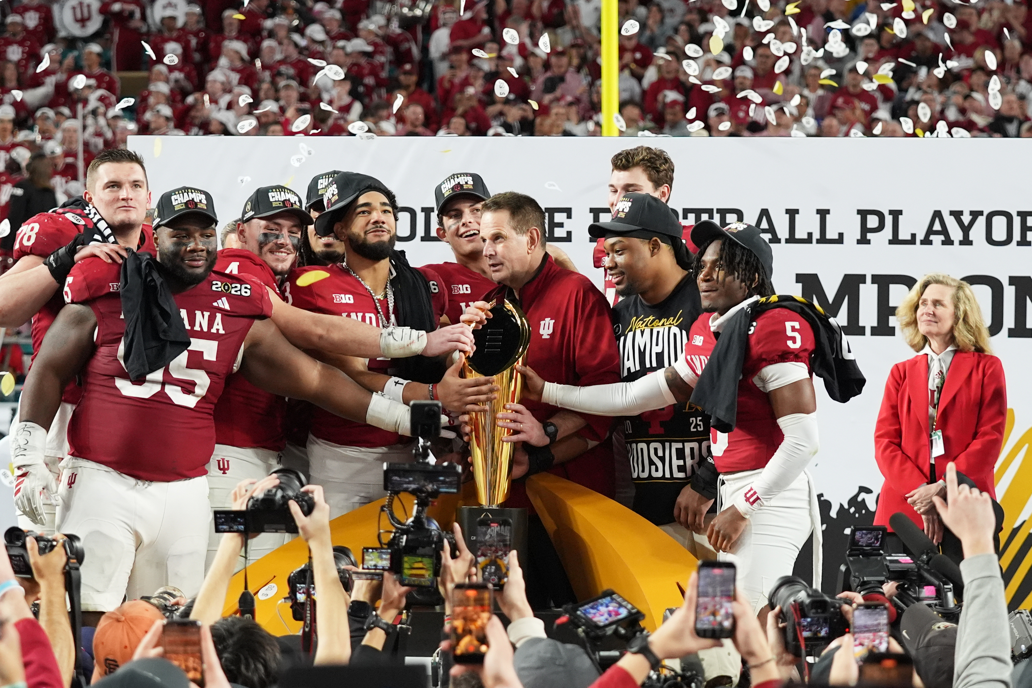 FILE - Indiana head coach Curt Cignetti, third from right, stands with players and the trophy after Indiana defeated Miami in a College Football Playoff national championship game, Jan. 19, 2026, in Miami Gardens, Fla. 